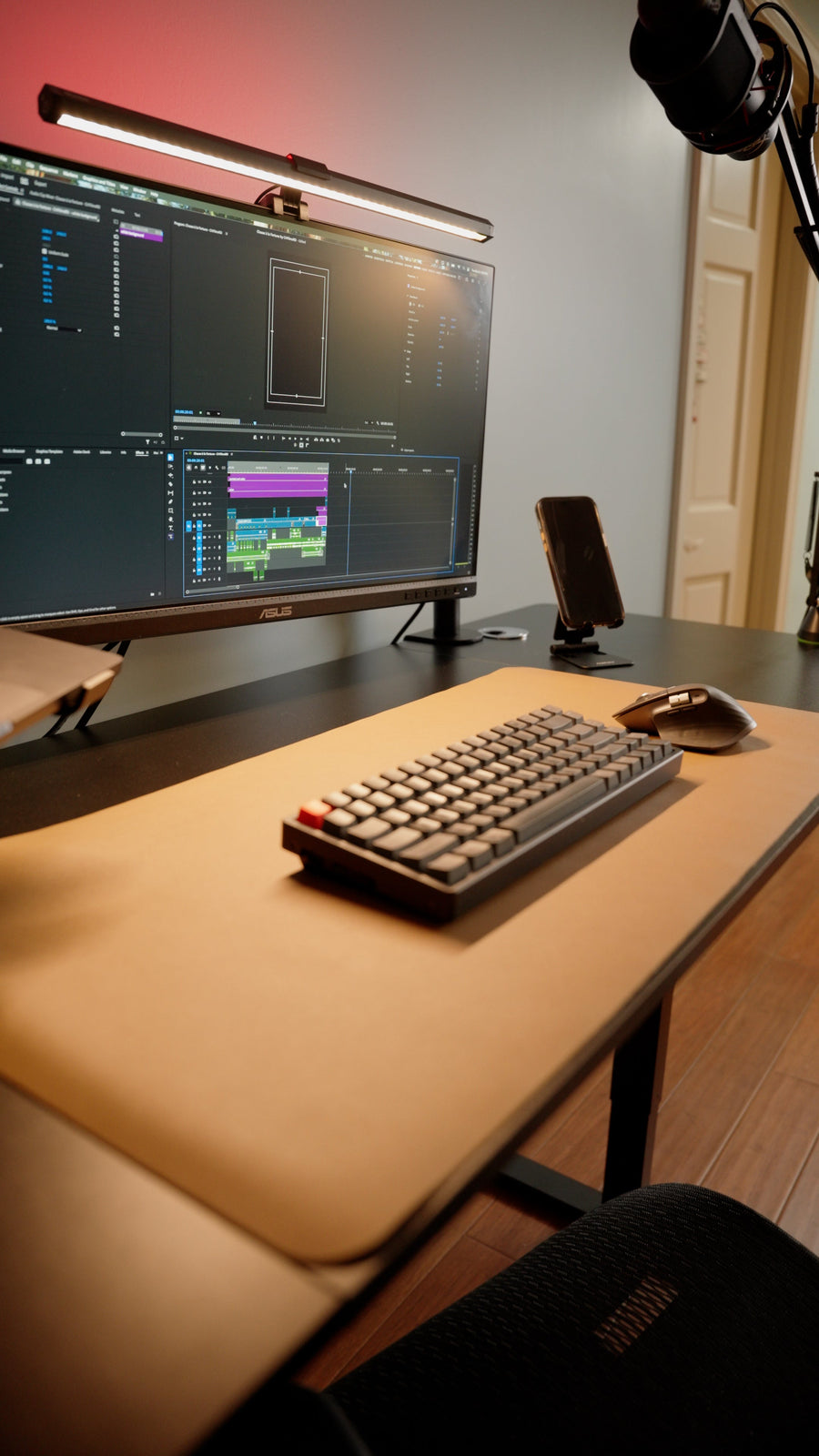 Computer desk with a monitor light bar illuminating the keyboard and desk mat