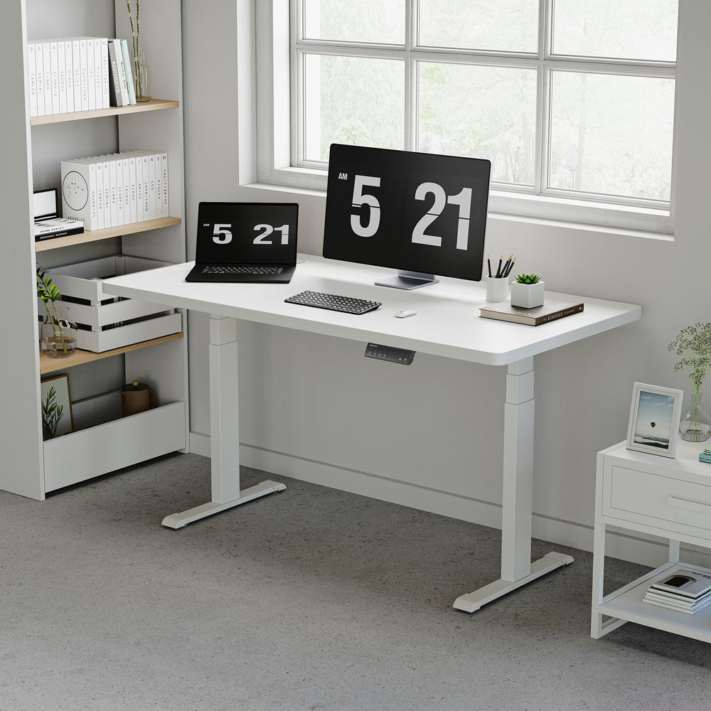White OdinLake S450 standing desk with a laptop, monitor, keyboard, mouse, and visible control keypad